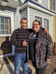 Katie and her husband standing in front of their new home in Harrisonburg