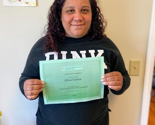 FSS Graduate Alina holding graduation certificate at the Reservoir St Office