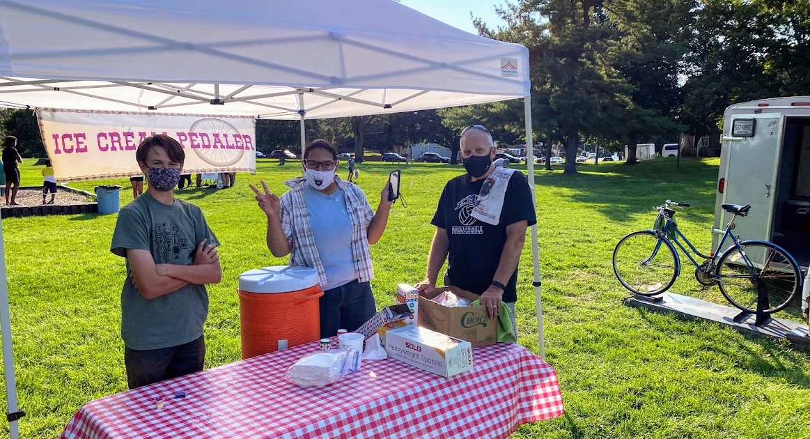 David King of the Ice Cream Pedaler stands with two HHS students at the Back to School Bash under a canopy. 